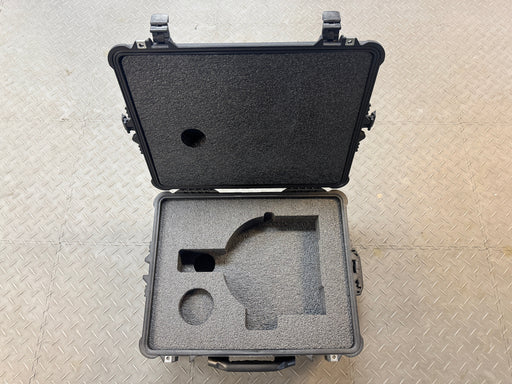 Black protective case with foam interior on a textured gray surface